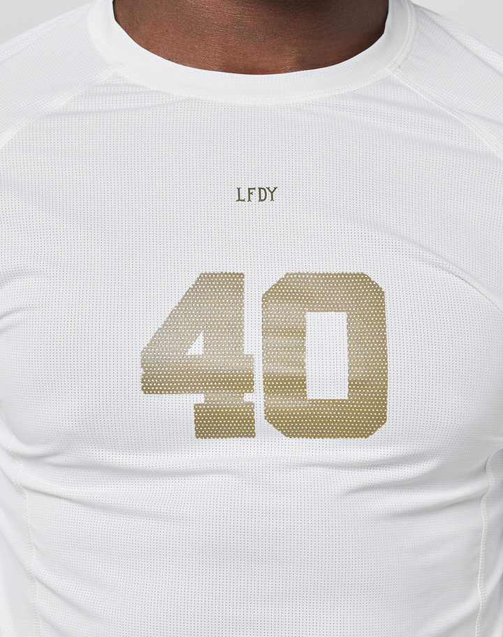 A person wears the LFDY Performance Slim Longsleeve from LIVE FAST DIE YOUNG, featuring a white design, gold number 40, small “LFDY” above the chest numbers, and a mesh insert for breathability.