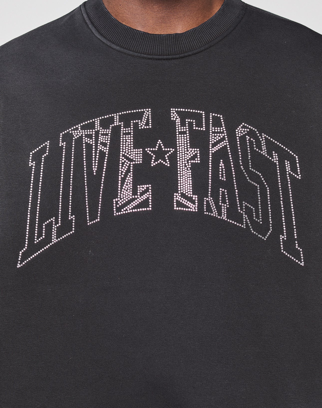 The Live Fast Rhinestone Sweater by LIVE FAST DIE YOUNG features bold, white, studded "LIVE FAST" lettering and a sparkling rhinestone logo for standout style.
