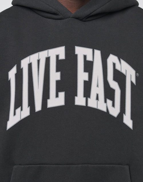 A close-up of the Live Fast College Hooded by LIVE FAST DIE YOUNG, an oversized black hoodie with LIVE FAST boldly printed in large white letters across the chest.