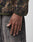 A close-up of a person’s hand at their side, wearing the LIVE FAST DIE YOUNG LFDY Fleece Longsleeve in green and brown polyester with faded gray jeans featuring visible stitching.