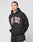 A person with braided hair poses against a white background, hands behind their back, wearing the Live Fast College Hooded by LIVE FAST DIE YOUNG—a black oversized hoodie with bold white and red LIVE FAST print, made from 65% Baumwolle.