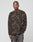 A person with a neutral expression wears an oversize LFDY Fleece Longsleeve by LIVE FAST DIE YOUNG, featuring a camo pattern, paired with faded black jeans, standing against a plain light gray background.