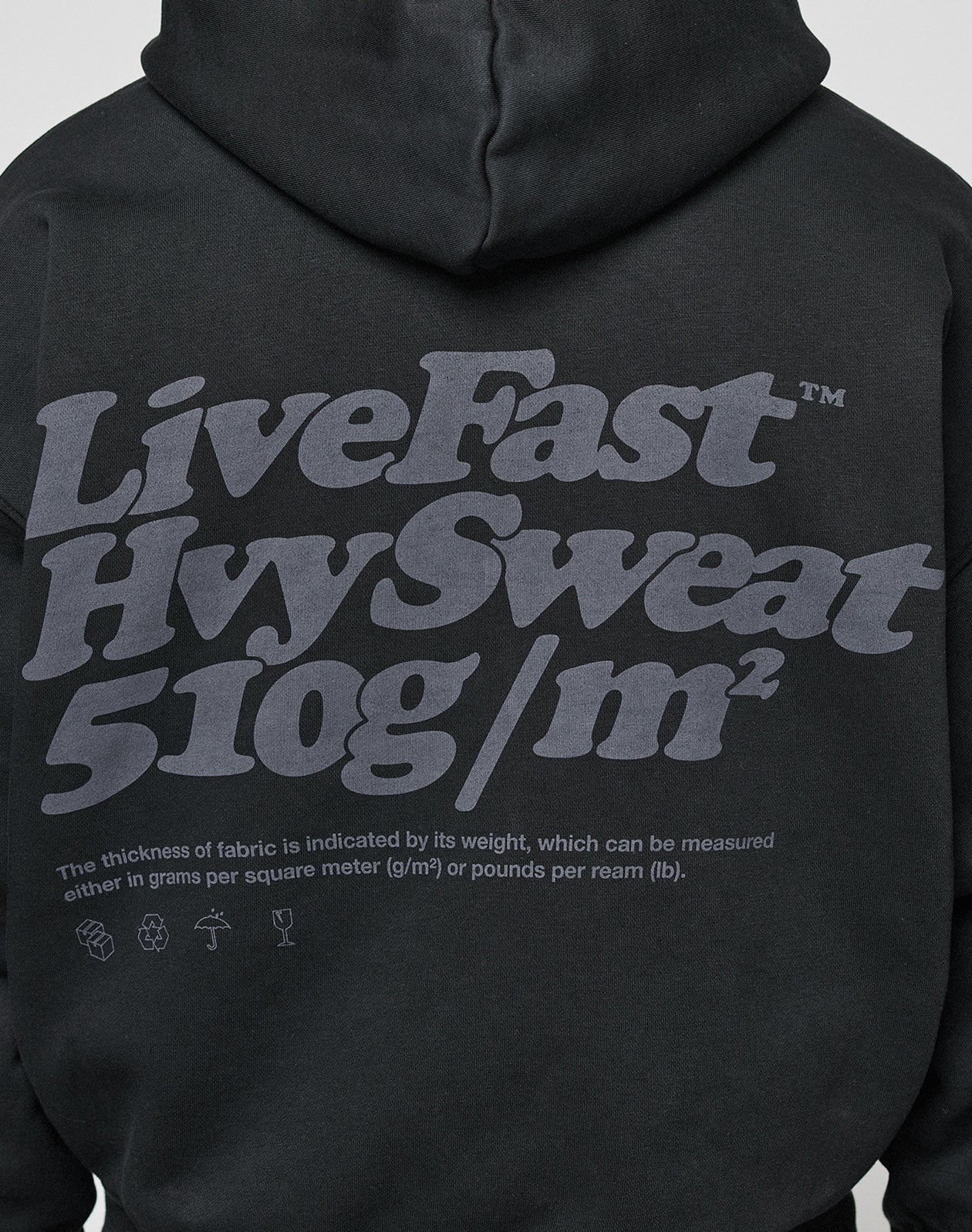 The LIVE FAST DIE YOUNG Basic 510 Hooded Zip is a black hoodie with bold gray “LiveFast HvySweat 510 gsm” text on the back, oversize fit, small text explaining fabric thickness, and detailed icons along the bottom.