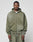 A man faces forward wearing an olive green Basic Hooded Zip and matching sweatpants from LIVE FAST DIE YOUNG, featuring a subtle faded look and a small white LIFY logo on the chest. The background is plain light gray.