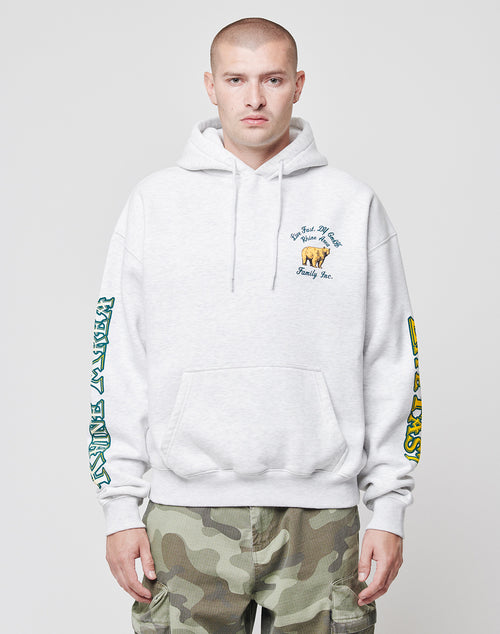A person in a light gray LIVE FAST DIE YOUNG Rhine Area Hooded hoodie with sleeve and chest graphics, paired with camouflage cargo pants, stands against a plain white background.