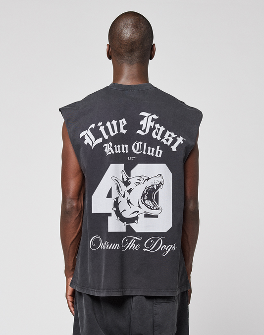 A person faces away, wearing the LFDY Run Club Muscle Shirt by LIVE FAST DIE YOUNG—an oversized, sleeveless black top with bold white "Live Fast Run Club" text, a large number 40, dog graphic, and "Outrun The Dogs" on the back for a vintage look.