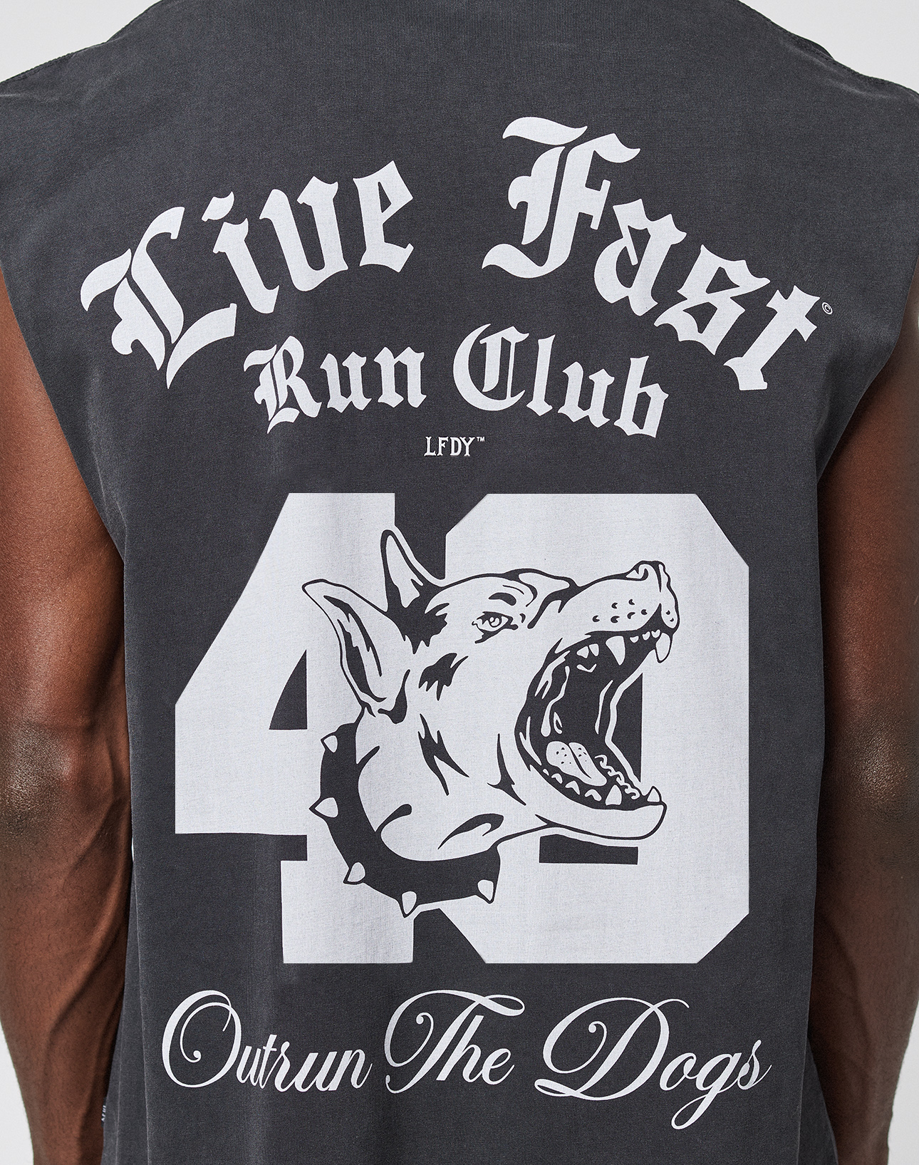 The LFDY Run Club Muscle Shirt by LIVE FAST DIE YOUNG features a bold "Live Fast Run Club" print, large number 40, snarling dog graphic, and "Outrun The Dogs" cursive on the back for a cool vintage look and oversized fit.