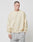A person with short hair wears the LIVE FAST DIE YOUNG Basic Blank Sweater in light beige, featuring an Oversize Fit, along with light gray pants, standing against a plain white background with a neutral expression.
