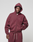 A person wears the LIVE FAST DIE YOUNG Basic Hooded Zip in maroon with the hood up and matching sweatpants, standing against a light gray background and looking at the camera with one hand in their pocket.