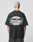 A person with short, bleached blonde hair is seen from behind wearing the LFDY Bulge Tee by LIVE FAST DIE YOUNG—an oversized black cotton T-shirt with bold front and back prints reading Everybody Eats Livefast in white and black.