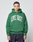 A person wears the LIVE FAST DIE YOUNG Live Fast College Hooded, an oversize fit hoodie in Baumwolle Polyester with a bold white 'LIVE FAST' frontprint, standing against a plain light gray background and looking at the camera.