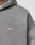 Close-up of a person wearing the LIVE FAST DIE YOUNG Basic Hooded Zip in faded gray with subtle distressing and a small white LFDY™ logo embroidered on the chest. The lightly cropped fit shows part of the shoulder and upper chest.