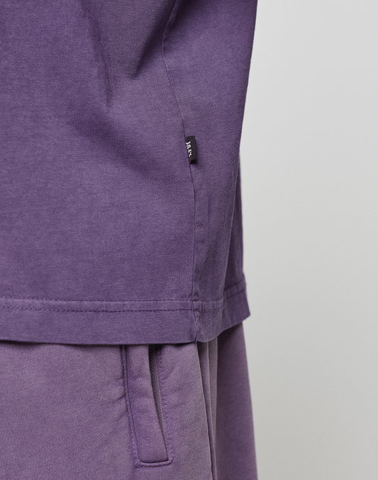 Close-up of a person wearing the Basic OS Livefast Tee and matching purple pants in an oversized fit by LIVE FAST DIE YOUNG. The image highlights the side seam and pocket area. Made from 100% cotton.