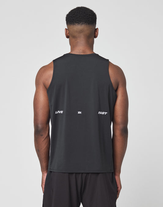 A man with short hair wears the LIVE FAST DIE YOUNG Live Fast Performance Tank, a slim fit sleeveless black athletic shirt in Nylon Spandex. LIVE FAST and a small reflective logo show in white on the back. He stands before a plain light background.