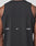 A close-up of a persons back in the Live Fast Performance Tank by LIVE FAST DIE YOUNG, a slim fit black sleeveless nylon-spandex shirt featuring LIVE and FAST in white, divided by a small reflective print at the center.