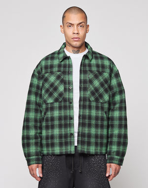 A person wearing a green and black LIVE FAST DIE YOUNG LFDY Padded Flannel over a white shirt stands facing forward against a plain light background.