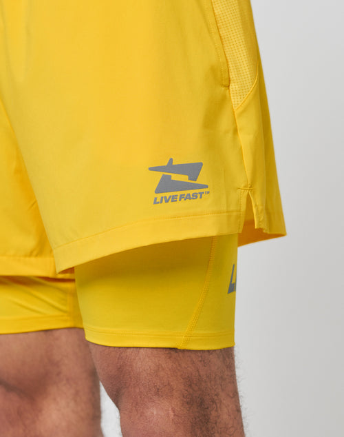 Close-up of legs in Live Fast Performance Running Shorts by LIVE FAST DIE YOUNG, featuring bright yellow color, stylized left thigh design, and leichtes Obermaterial for comfort.