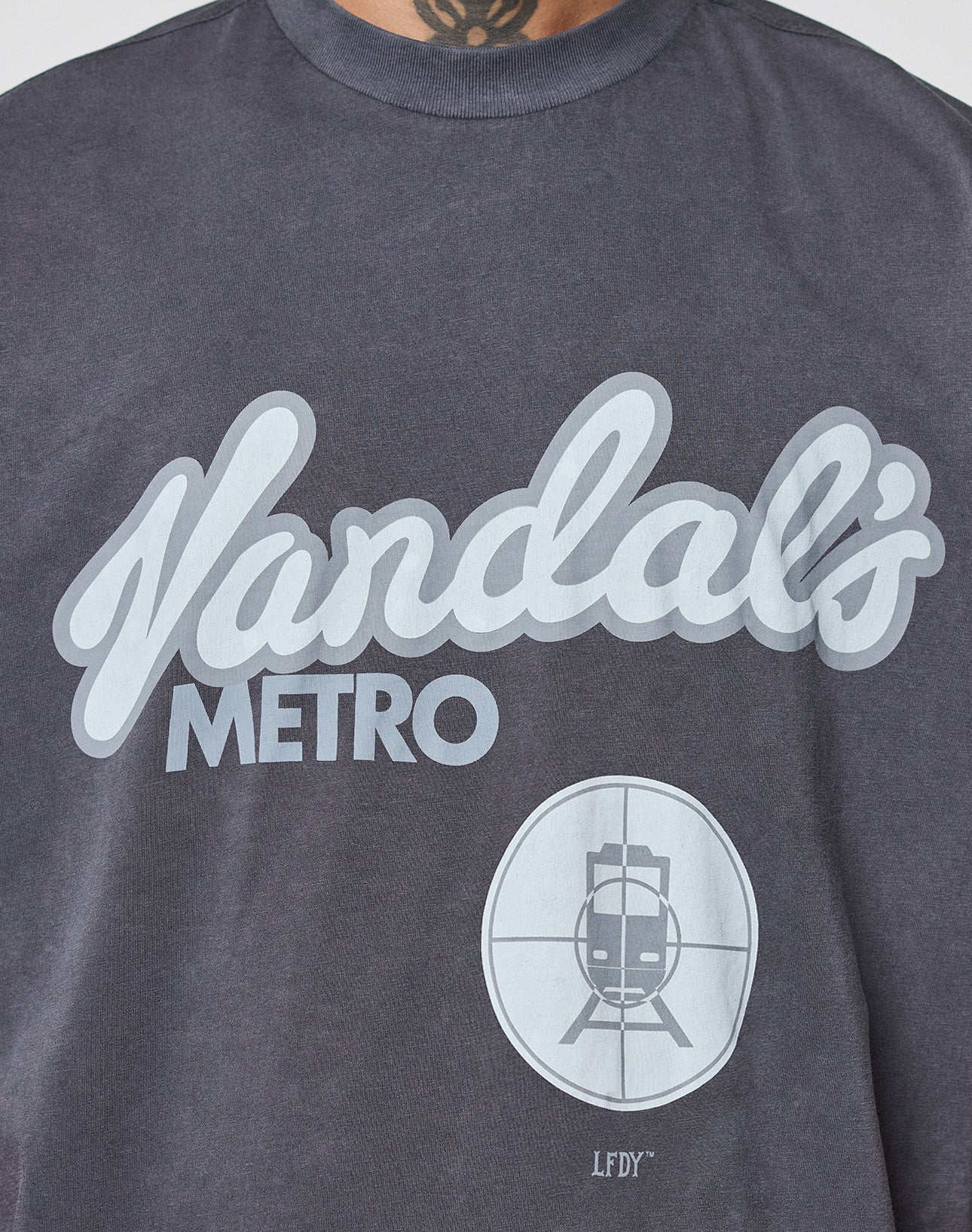 A close-up of the LFDY Vandals Tee by LIVE FAST DIE YOUNG, a dark gray 100% Baumwolle T-shirt with bold "Vandals METRO" text, a frontprint of a train in crosshairs, and "LFDY" initials below.