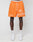 Wearing LIVE FAST DIE YOUNGs LFDY Praying Mesh Shorts in orange, featuring a regular fit, praying hands graphic, cross, and Live Fast text. Made from polyester with an elastic waistband. Paired with white socks and sneakers.