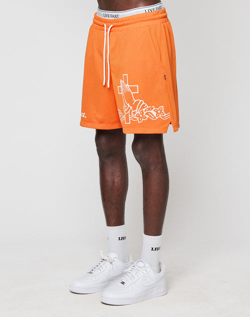 A person wearing LIVE FAST DIE YOUNG LFDY Praying Mesh Shorts in orange with white graphics, white socks, and Nike Air Force 1 sneakers stands against a plain white background. Only the lower half of the body is visible.
