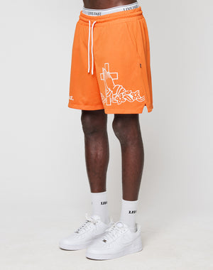 A person wearing LIVE FAST DIE YOUNG LFDY Praying Mesh Shorts in orange with white graphics, white socks, and Nike Air Force 1 sneakers stands against a plain white background. Only the lower half of the body is visible.