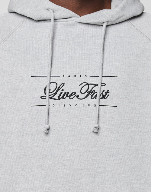 Close-up of the light gray LFDY Embroidery Hooded by LIVE FAST DIE YOUNG, featuring raglan sleeves, hood with drawstrings, and "PARIS Live Fast DIE YOUNG" in black script and block letters on the chest.