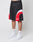 A person wearing LIVE FAST DIE YOUNG Basic Trackshorts in black with red and white curves, paired with white LEDY socks and white Nike sneakers, stands against a plain white background.