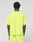A person with short curly hair faces away from the camera, wearing a bright yellow LIVE FAST DIE YOUNG Basic OS Livefast Tee and matching shorts against a plain, light background.
