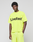 A man stands against a plain background wearing the LIVE FAST DIE YOUNG Basic OS Livefast Tee, an oversized bright yellow T-shirt made from 100% Baumwolle with "LiveFast" printed in large black letters on the front.