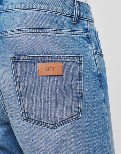 Close-up of the back pocket on LIVE FAST DIE YOUNG’s Regular Denim jeans, featuring a brown leather patch embossed with LFDY and signature branding.