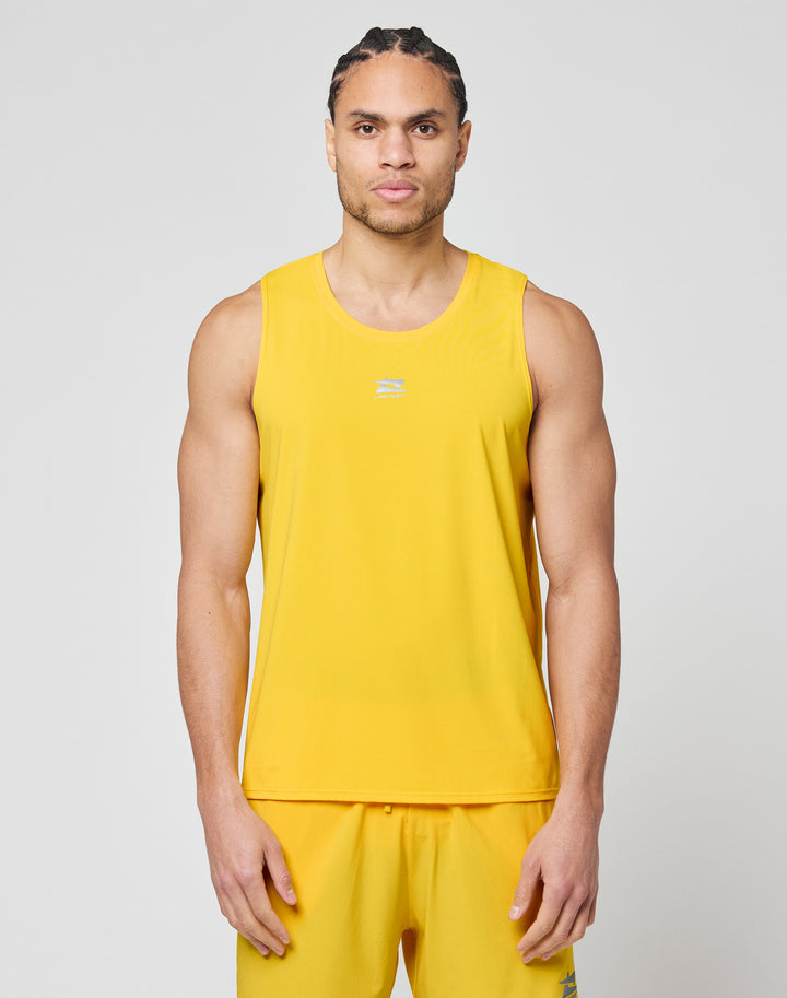 A man with braided hair wears the LIVE FAST DIE YOUNG Live Fast Performance Tank and matching yellow shorts with reflective print, standing against a plain light gray background.