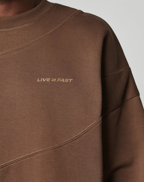 Close-up of the LFDY Wavy Sweater by LIVE FAST DIE YOUNG, featuring soft Baumwolle-blend fabric, diagonal seam accents, LIVE FAST in subtle chest text, and an Oversize Fit emphasized on the upper torso.