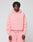 A person with short, curly hair wears an oversize fit Basic 360 Hooded and sweatpants in pink by LIVE FAST DIE YOUNG, made from Baumwolle with topstitching and a small LiveFast logo on the chest. The background is plain light gray.