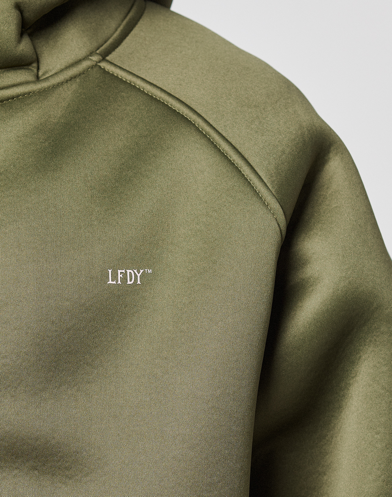 Close-up of the LFDY Scuba Hooded Zip by LIVE FAST DIE YOUNG in olive green, featuring a white LFDY™ chest logo, visible seams, Kapuze, and smooth fabric texture.