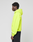 A person in a neon yellow LIVE FAST DIE YOUNG Basic Hooded Zip and black pants stands in profile against a plain light gray background.