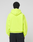 A person faces away from the camera, wearing an oversize fit LIVE FAST DIE YOUNG Basic Hooded Zip in bright yellow and black pants with a back pocket, set against a plain light gray background.