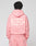 Person with short, twisted hair facing away, wearing an Oversize Fit pink Basic 360 Hooded and pants by LIVE FAST DIE YOUNG. The hoodie has bold white "LiveFast HvySweat 360g/m²" text and visible topstitching on the back. Background is plain light gray.