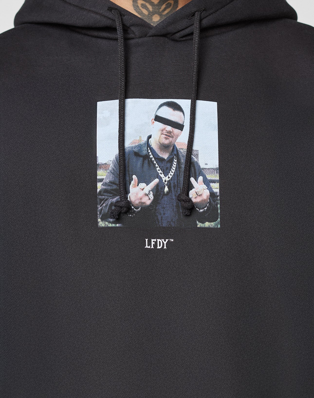 The LFDY Gambling Hooded by LIVE FAST DIE YOUNG is a black, oversized hoodie featuring a bold photo frontprint of a man with eyes censored by a white bar, wearing chains, making hand gestures, and "LFDY" written below.