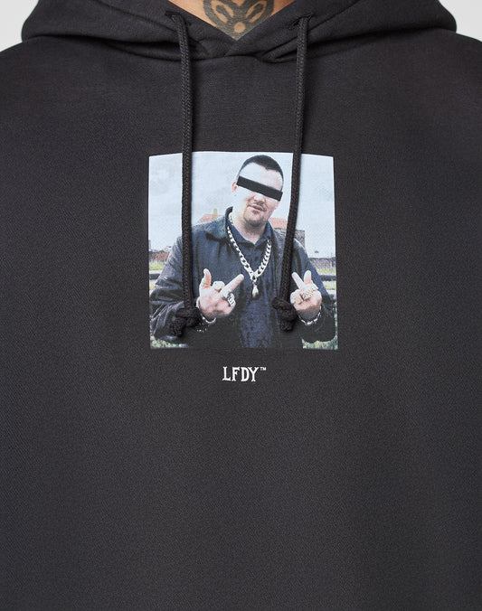 The LFDY Gambling Hooded by LIVE FAST DIE YOUNG is a black, oversized hoodie featuring a bold photo frontprint of a man with eyes censored by a white bar, wearing chains, making hand gestures, and "LFDY" written below.