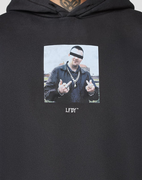 The LFDY Gambling Hooded by LIVE FAST DIE YOUNG is a black hoodie with a bold front print: a man in jewelry and leather jacket, eyes censored, showing both middle fingers. Oversized fit, 360 GSM fabric, and LFDY text below the image ensure comfort and style.