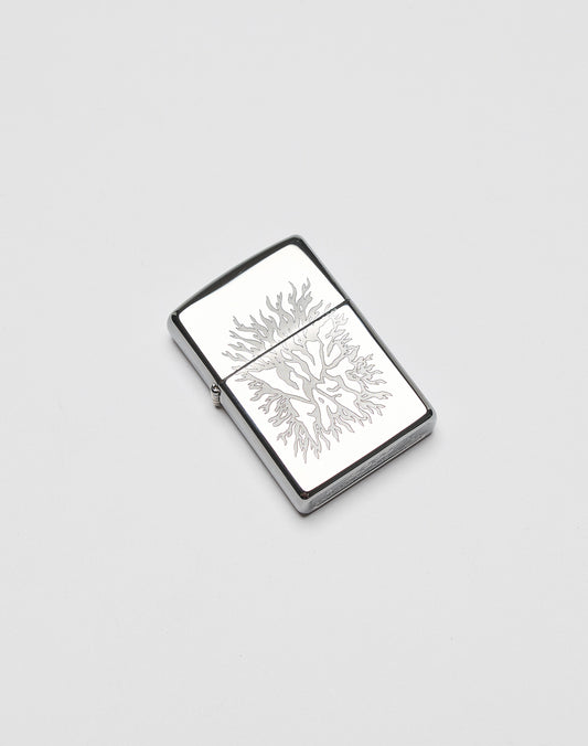 A silver rectangular LFDY x Zippo lighter by LIVE FAST DIE YOUNG features an engraved flame design on its aluminium case, displayed on a plain white background.