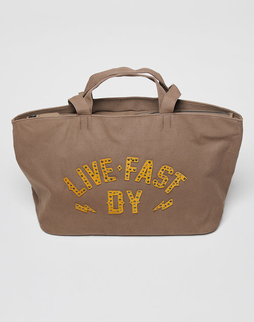 The LFDY Tote Bag by LIVE FAST DIE YOUNG is a brown Rindsleder bag with short handles, yellow LIVE FAST DY lettering and lightning bolts on the front, plus a convenient Laptop Fach for daily use.