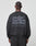 A person with braided hair is seen from behind wearing the Basic Acid Sweater by LIVE FAST DIE YOUNG, an oversized black sweatshirt with bold gray text and vintage-wash details, crafted from a soft cotton-polyester blend.