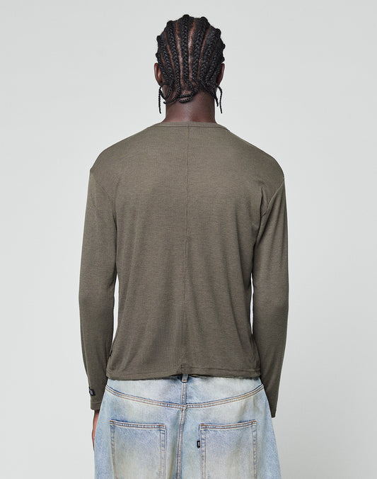 A person with braided hair is seen from behind wearing the LIVE FAST DIE YOUNG LFDY Rib Longsleeve in olive-green and light blue jeans, standing against a plain light gray background.