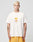 A person with short, bleached blonde hair wears a loose white LFDY Fries Tee by LIVE FAST DIE YOUNG, featuring a graphic of fries in a red carton labeled “Everybody Fries,” and yellow shorts, against a plain light gray background. LF2406-15695.