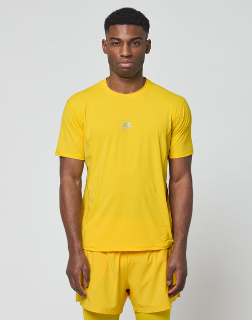A man faces forward in the LIVE FAST DIE YOUNG Live Fast Performance Tee and matching shorts, slim fit, bright yellow with reflective print, set against a plain light gray background.
