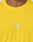 Close-up of a person in the LIVE FAST DIE YOUNG Live Fast Performance Tee, a bright yellow slim fit athletic shirt with a white LIVE FAST logo and reflective chest print. Only the lower face and upper chest are visible.