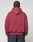 A person with braided hair is seen from behind, wearing the LIVE FAST DIE YOUNG Live Fast Stallion Hooded in maroon, featuring an oversize fit and soft polyester-cotton blend, paired with dark jeans against a plain light background.