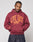 Someone wearing the Live Fast Stallion Hooded by LIVE FAST DIE YOUNG, a maroon oversized hoodie featuring yellow LIVE FAST text and two tigers graphic, made from a soft cotton-polyester blend, stands with hands in the pocket and looks down.