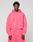 A person stands facing forward in an oversized bright pink LIVE FAST DIE YOUNG Basic Hooded Zip with matching sweatpants, set against a plain light gray background.